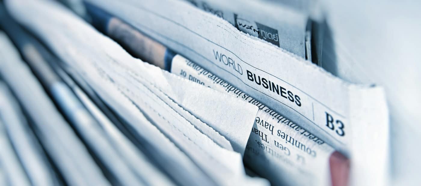 Pile de journaux ouverts sur une page économie